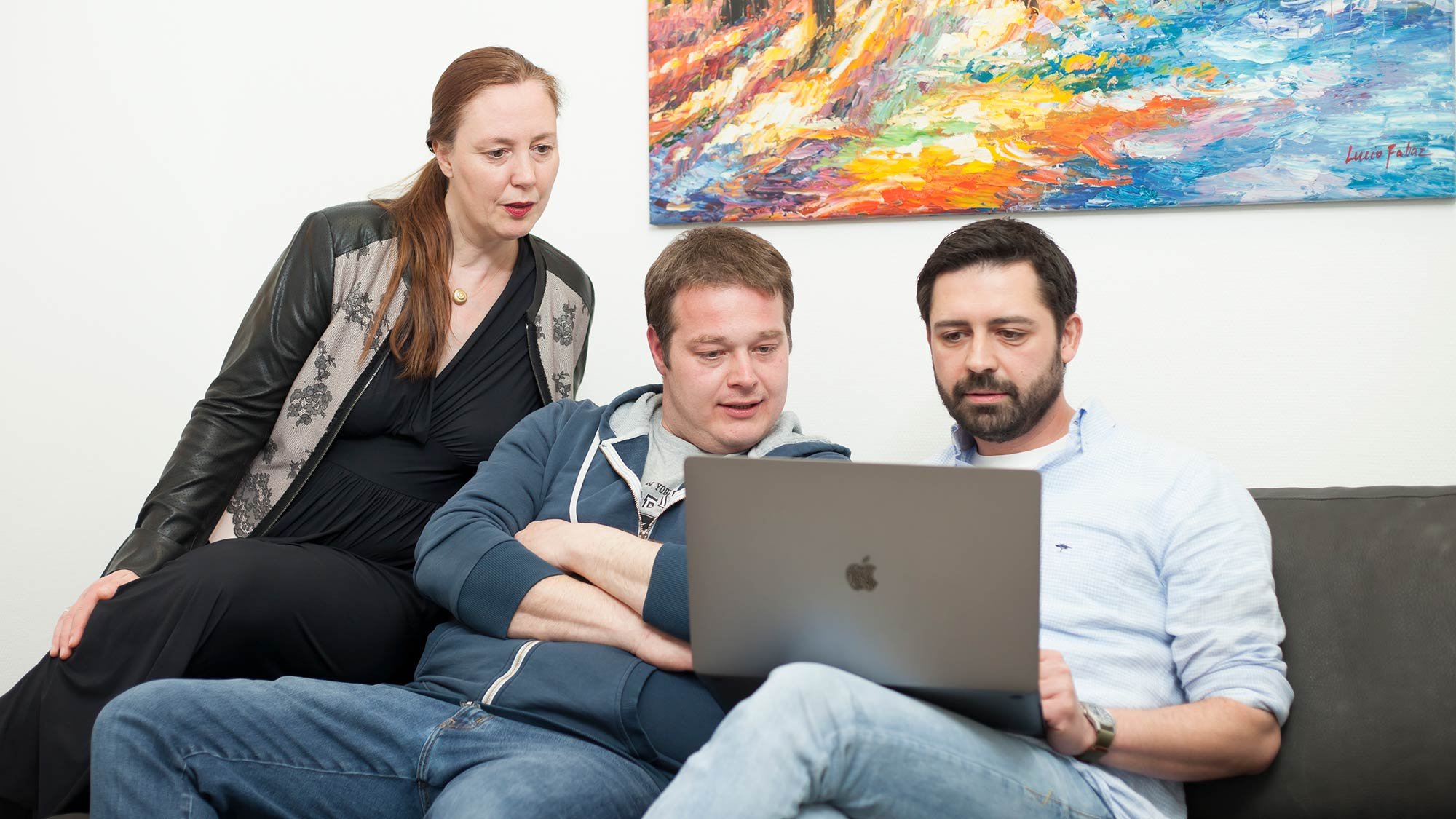 Mitarbeitende mindmelt auf einer Couch mit Blick in ein Laptop