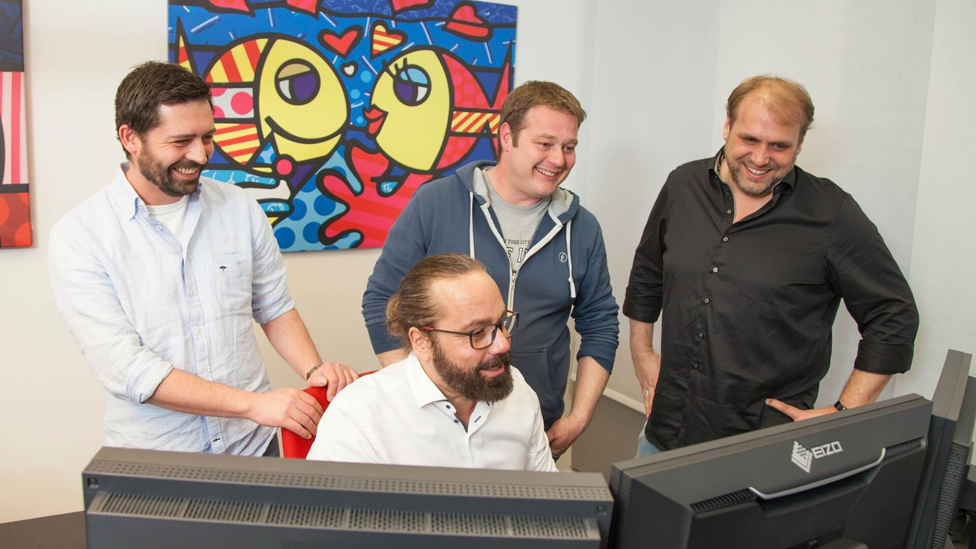 mindmelt Team wertet gemeinsam Zahlen am Monitor aus